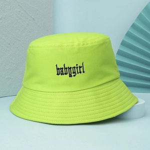 Dettaglio del ricamo babygirl nero in stile gotico sul cappello a secchiello verde neon