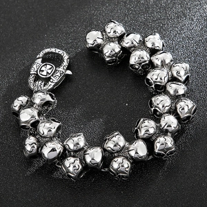 Detail of vintage gothic skull bracelet with cross motif clasp on black background