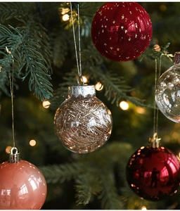 Close-up of red and gold glitter Christmas ball ornaments hanging on a festive tree branch