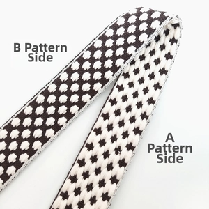 Detail of adjustable thick knitted bag strap showing black and white jacquard textures
