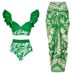 Three-piece bikini set with green tropical print, ruffle top, and matching sarong skirt