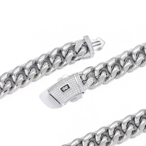 Macro detail of silver Cuban link necklace with iced-out zirconia clasp and logo