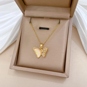 Detail of pink gradient butterfly necklace with white zircons on white silk background