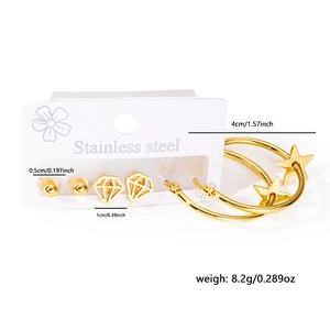 Macro detail of stainless steel earring set featuring gold star hoops and heart studs