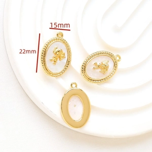 Macro detail of oval gold angel pendant with white shell inlay measuring 15mm by 22mm