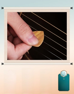Macro shot of a handcrafted wooden guitar pick showing natural wood grain held by hand