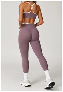 Achteraanzicht van paarse yoga-legging met hoge taille en sport-bh met witte bies