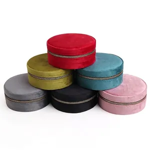 Round velvet jewelry boxes with zipper closures in multiple colors on white background