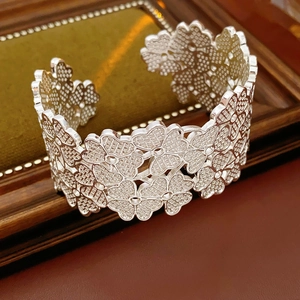 Detailed macro view of silver clover cutout pattern on adjustable open bangle