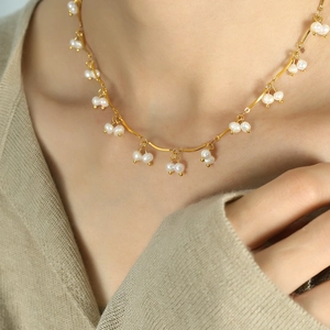 Elegant gold chain necklace with freshwater pearl tassels on model's neck