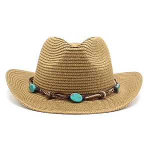 Détail du chapeau de cowboy en paille avec perles turquoise et bordure tressée