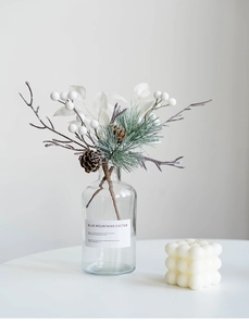 Close-up of pine cones and white berries in a glass bottle for Nordic home decoration