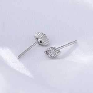 Macro shot of silver eye-shaped stud earrings with sparkling white cubic zirconia