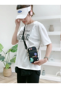 Detail of black nylon mini crossbody phone bag with colorful hot air balloon print