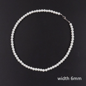 Detail view of long 6mm pearl necklace featuring silver lobster clasp on black background