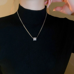 Close-up of gold-plated multi-layer zircon circle pendant necklace on a black turtleneck