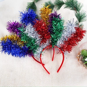 Dettaglio di cerchietti festivi colorati con frange metalliche su sfondo di morbido peluche