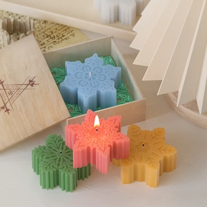 Gekleurde geurkaarsen in sneeuwvlokvorm in een houten geschenkdoos met vintage decor