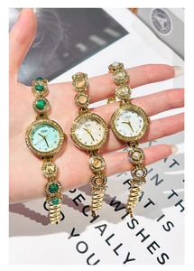 Gros plan de montres GEDI avec bracelets dorés, pierres émeraude et accents perles