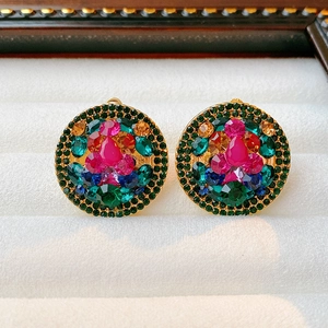 Macro detail of vintage gold clip earrings with multi-color rhinestones on velvet