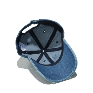 Internal structure of distressed denim cap with black reinforcement and size label