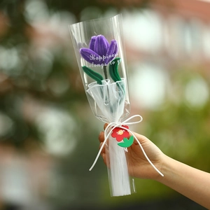 Close-up of a single purple plush tulip bouquet wrapped in a transparent sleeve