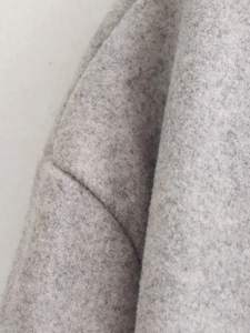 Gros plan sur le tissu polaire gris montrant la texture épaisse et les détails de couture