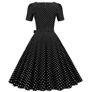 Back view of a vintage polka dot dress featuring a slim waist and wide A-line skirt