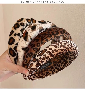 Macro shot of four different plush leopard print headbands held in hand for detail