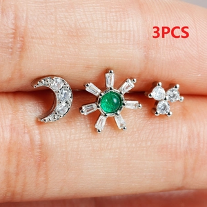 Macro view of 3pcs silver stud set featuring moon and sunflower with green zircon stones