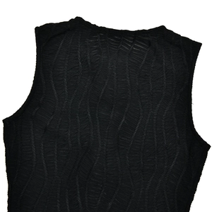 Gros plan d'une robe noire sans manches avec tissu texturé ondulé et détails transparents