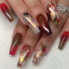 Detail of long ballerina press-on nails with red gradient and marble gold foil texture