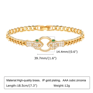 Detailed view of snake head gold bracelet with cubic zirconia and green gemstone eyes