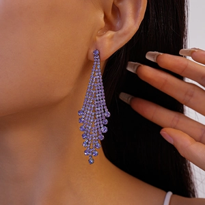 Close-up of elegant purple rhinestone fringe tassel earrings worn on a model's ear