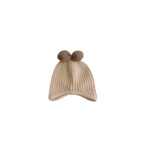 Winter knitted baby hat in beige with cute brown pompom bear ears for infants