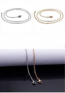 Detail of stainless steel O-chain and cross chain with lobster clasps in silver and gold