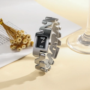 Detailed shot of a silver geometric chain watch with a sleek black rectangular dial
