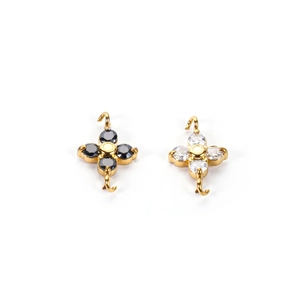 Macro shot of gold four-leaf flower connectors with black and white zircon stone inlays