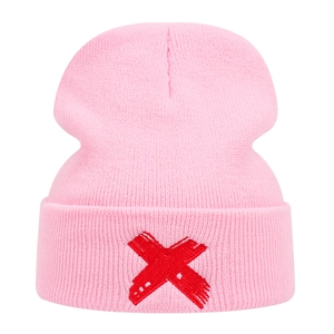 Bonnet en tricot rose avec une broderie X rouge présentant une texture de bandage unique