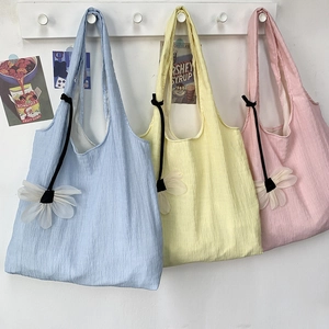 Detailed texture of colorful pleated canvas tote bags in pastel blue, yellow, and pink hues