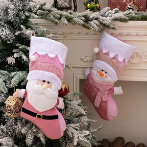 Pink and white plush Christmas stockings with 3D Santa and snowman hanging on a fireplace