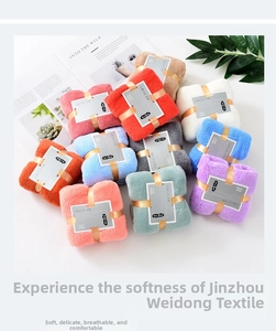 Close-up of soft coral fleece face towels in various pastel colors with ribbon bows
