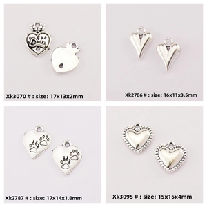 Detailed view of four antique silver heart charms with unique relief designs for DIY jewelry