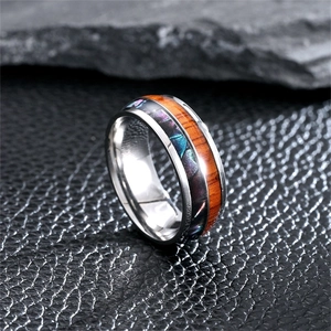 Close-up detail of a vintage stainless steel ring with wood inlay and shell texture