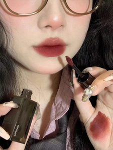 Close-up of deep red brown liquid lipstick texture and finish on lips and skin