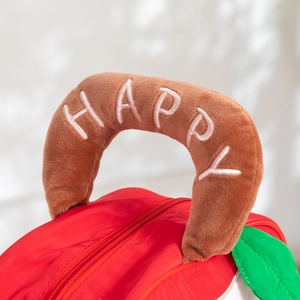 Detail of red apple-shaped gift bag featuring brown plush handle with HAPPY embroidery
