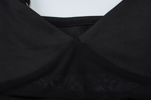 Detailed close-up of V-neckline featuring sheer mesh patchwork on a black dress