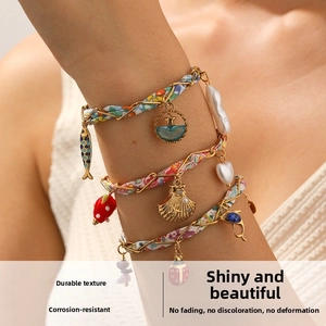 Gros plan détaillé d'un bracelet multi-rangs avec foulard en soie et pendentifs variés
