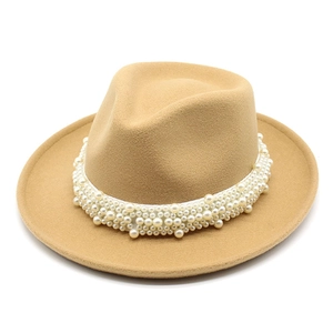 Detalle de sombrero fedora de lana color camello con filas de bandas de perlas blancas