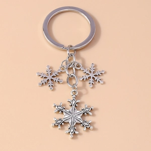 Detail shot of antique silver snowflake charms on a vintage alloy Christmas keychain